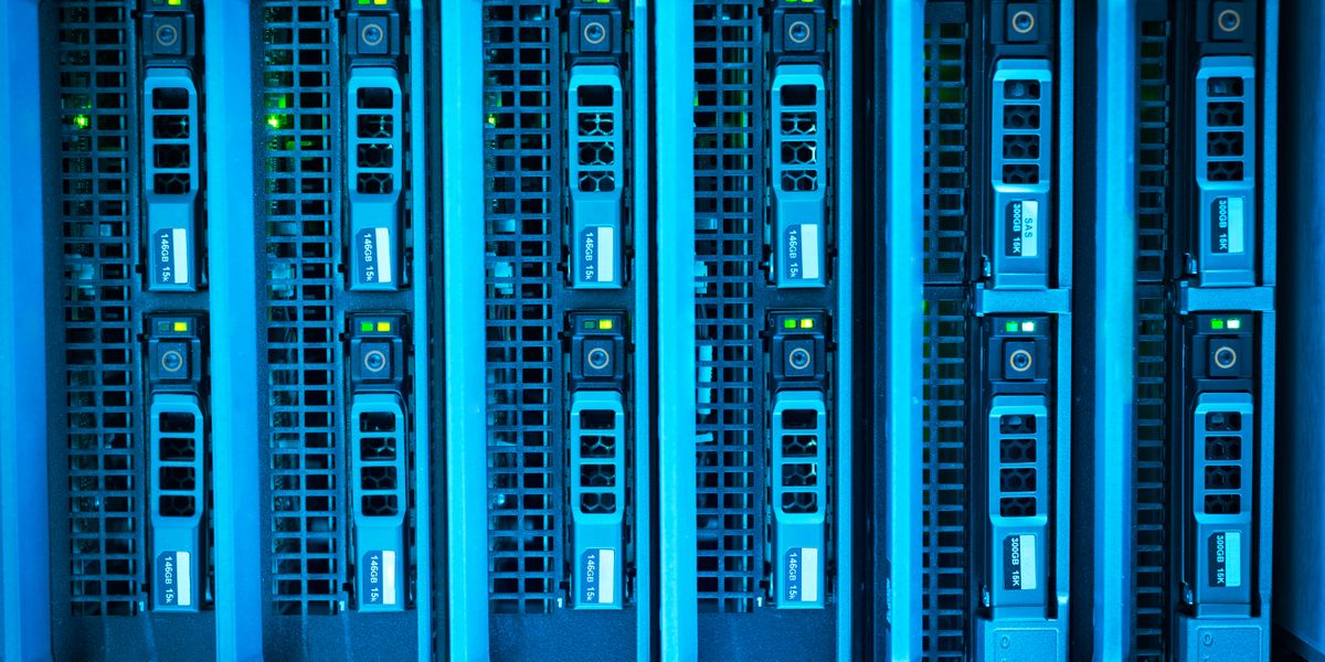 青色に照らされたサーバーブレードが並ぶデータセンター